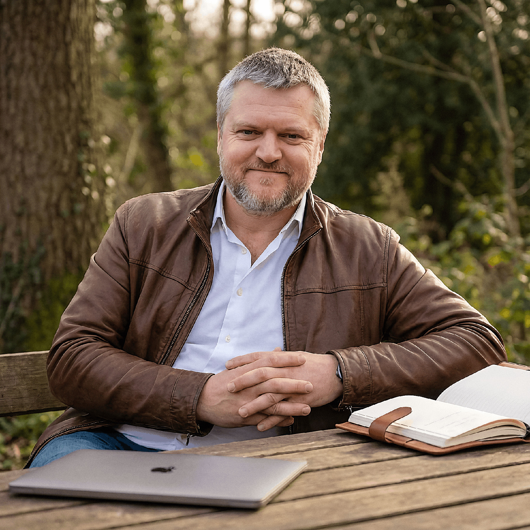 Alistair, your teacher, sitting outdoors with a laptop and notebook