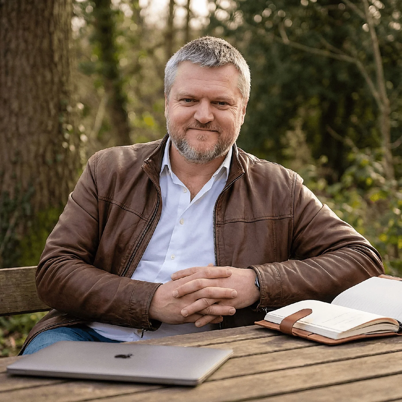 Alistair, your teacher, sitting outdoors with a laptop and notebook